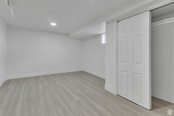 Basement with light wood-style flooring and recessed lighting