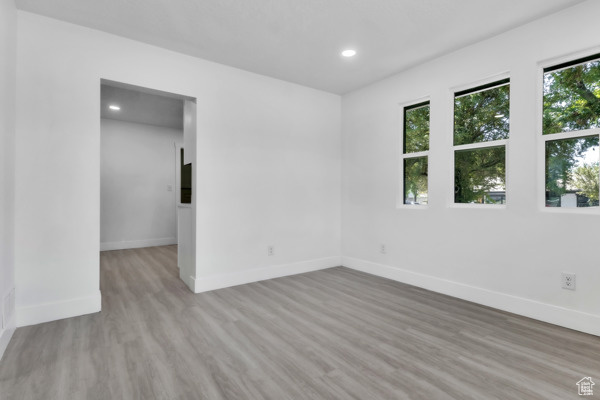 Spare room with wood finished floors and recessed lighting