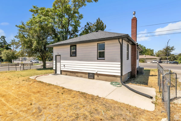 View of side of property with a chimney and a patio