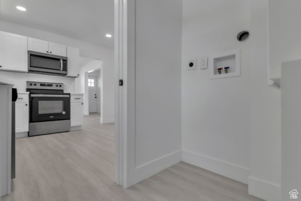 Laundry area with light wood-style flooring, recessed lighting, and washer hookup