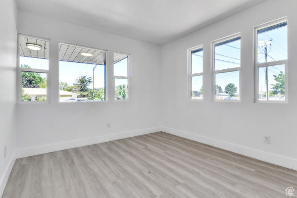 Empty room featuring baseboards and light wood-style flooring
