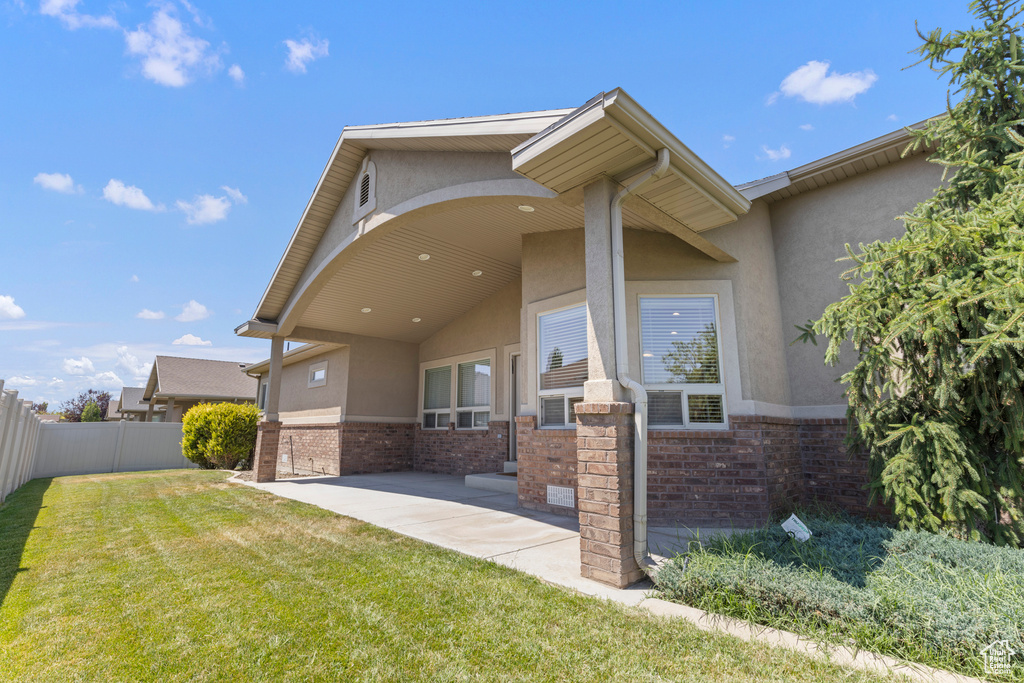 Rear view of house with stucco siding, brick siding, and a patio area