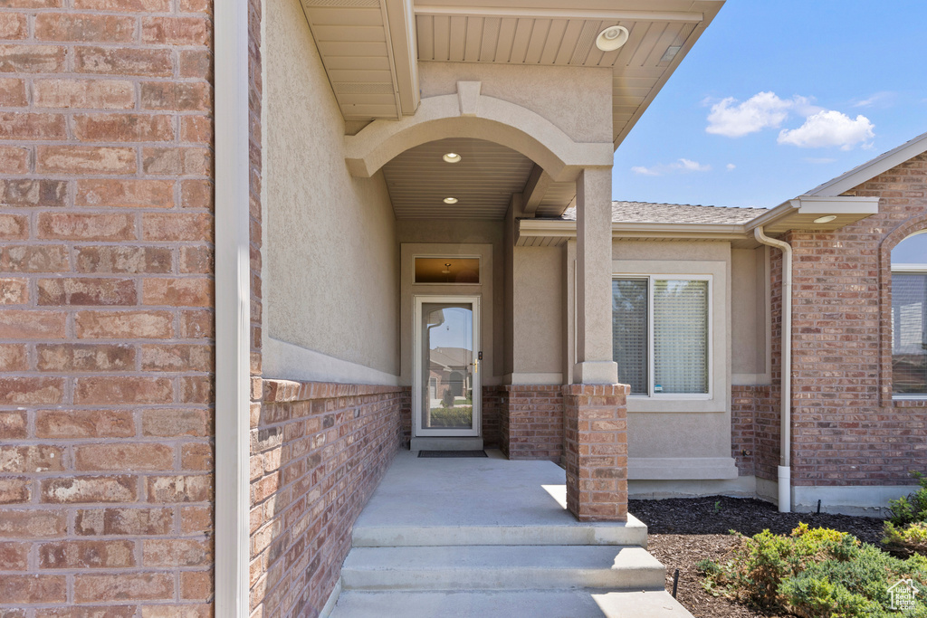 Property entrance with brick siding and stucco siding