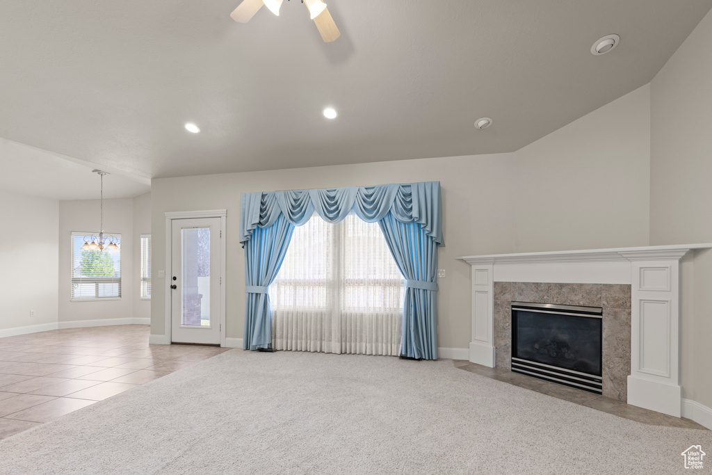 Unfurnished living room featuring a chandelier, a ceiling fan, a fireplace, recessed lighting, and light tile patterned flooring