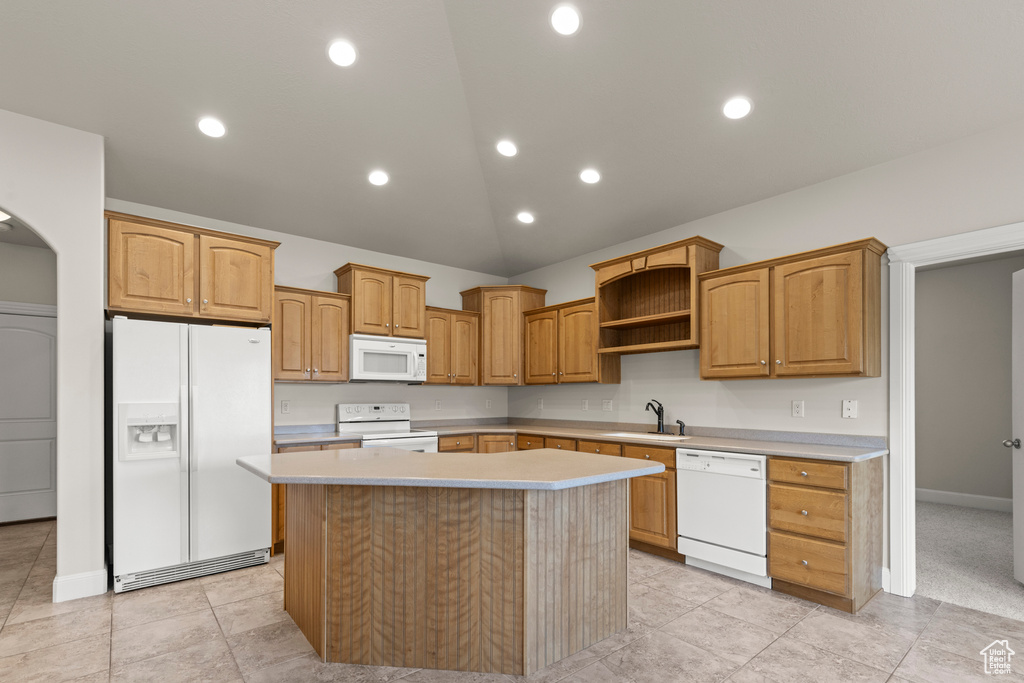 Kitchen featuring white appliances, a center island, light countertops, open shelves, and recessed lighting