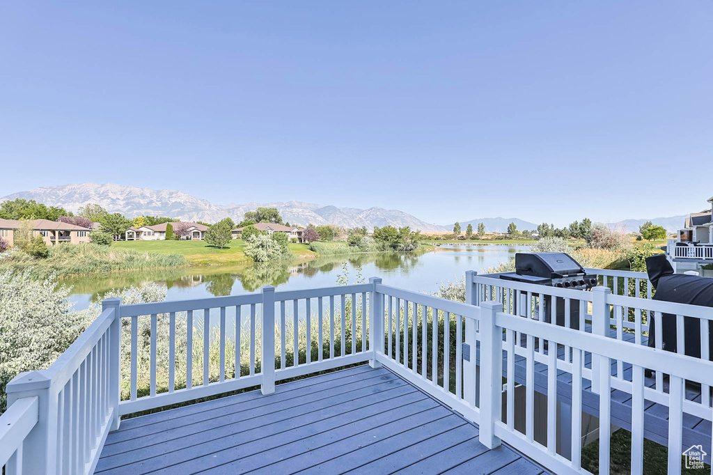 Wooden terrace featuring a water and mountain view