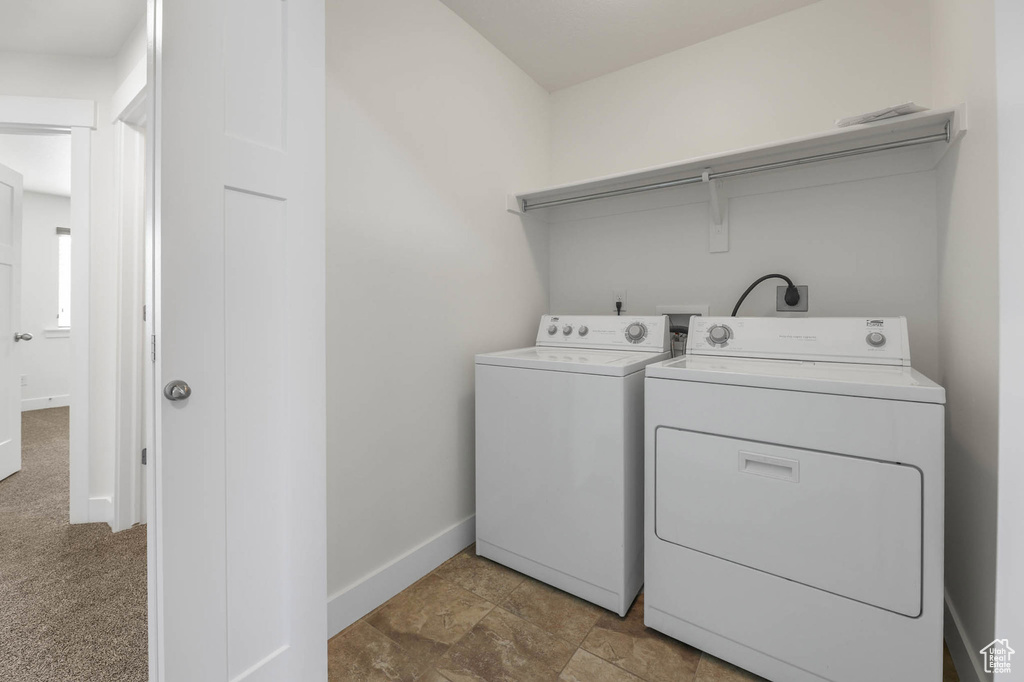 Laundry area with washer and clothes dryer and baseboards