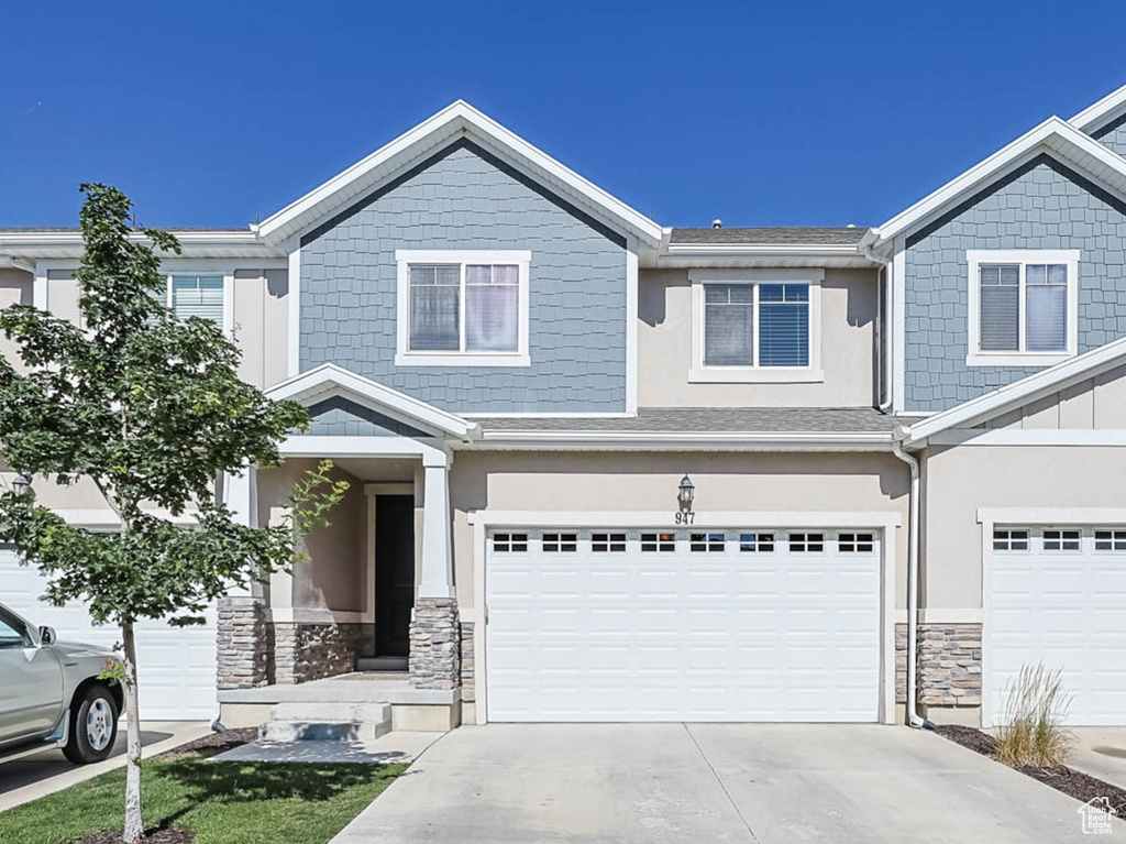 Craftsman inspired home with concrete driveway, stone siding, a garage, and board and batten siding