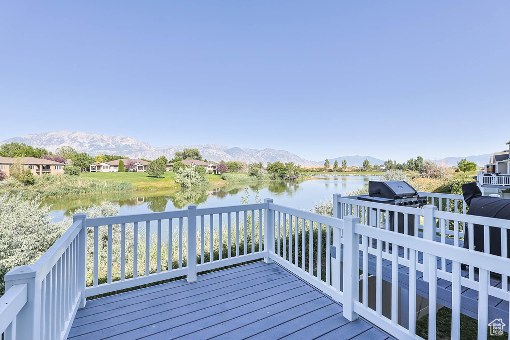 Wooden deck featuring a water and mountain view