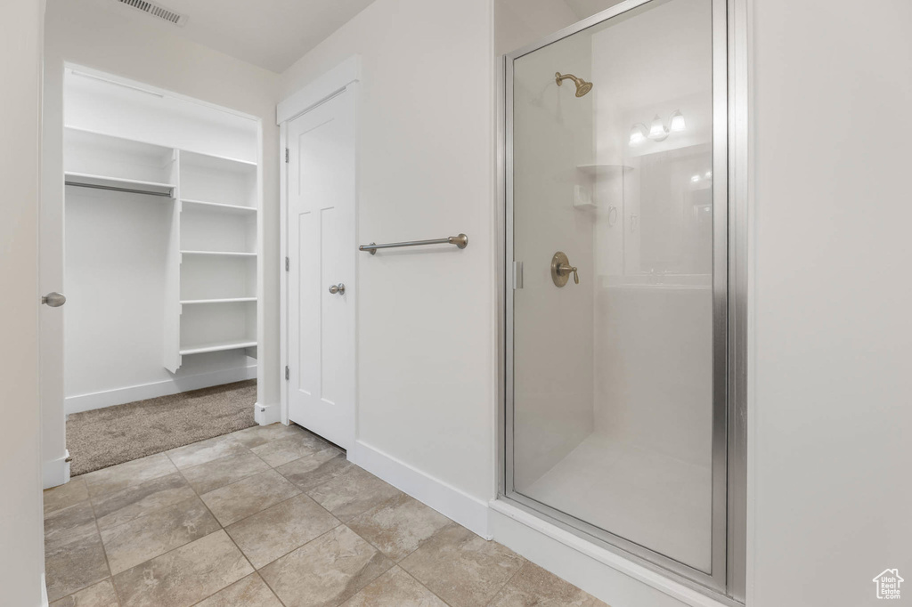 Bathroom featuring a stall shower and a walk in closet