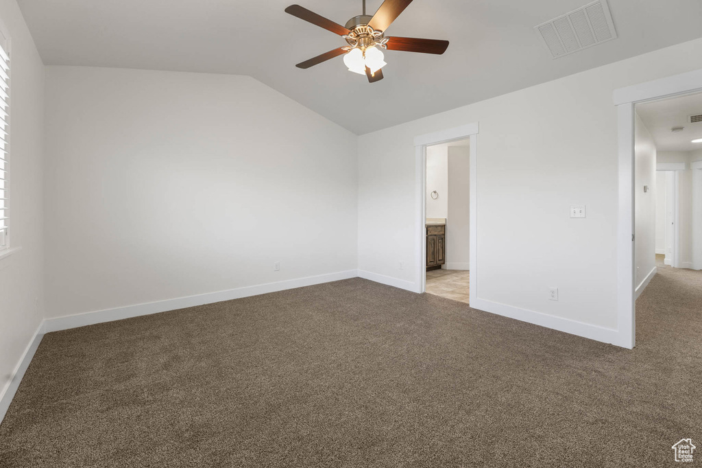 Unfurnished room with a ceiling fan, carpet floors, and vaulted ceiling