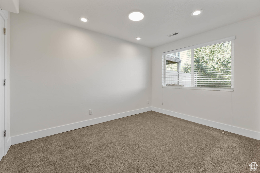 Carpeted empty room featuring recessed lighting