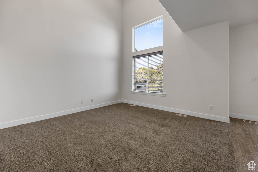 Spare room with baseboards and a towering ceiling