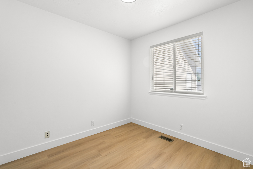 Empty room with baseboards and light wood-style floors