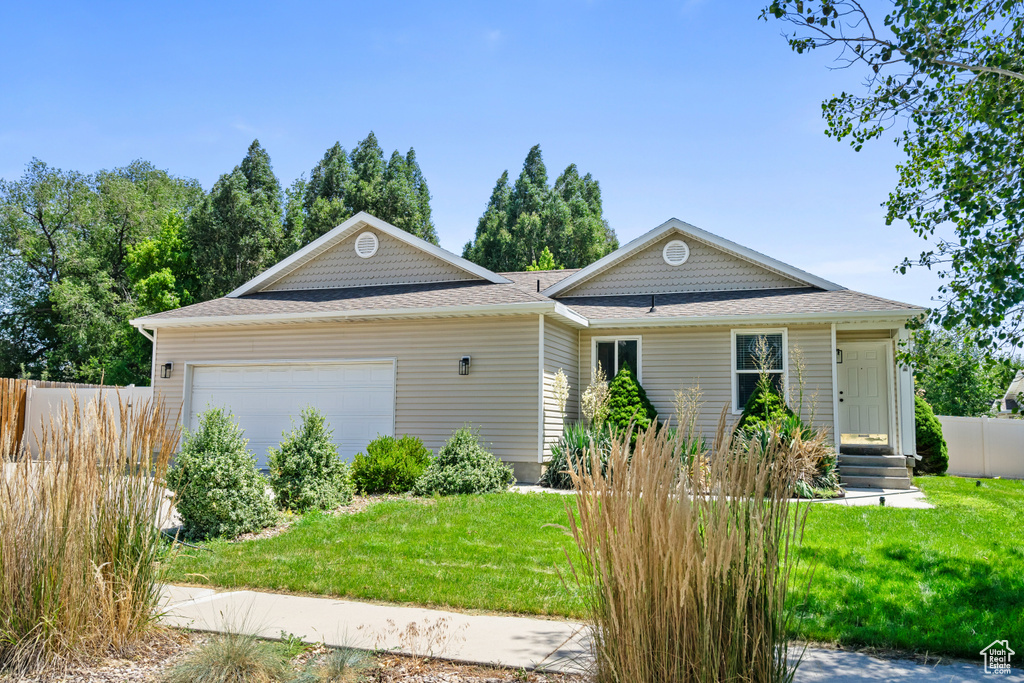 View of front of property featuring an attached garage and roof with shingles