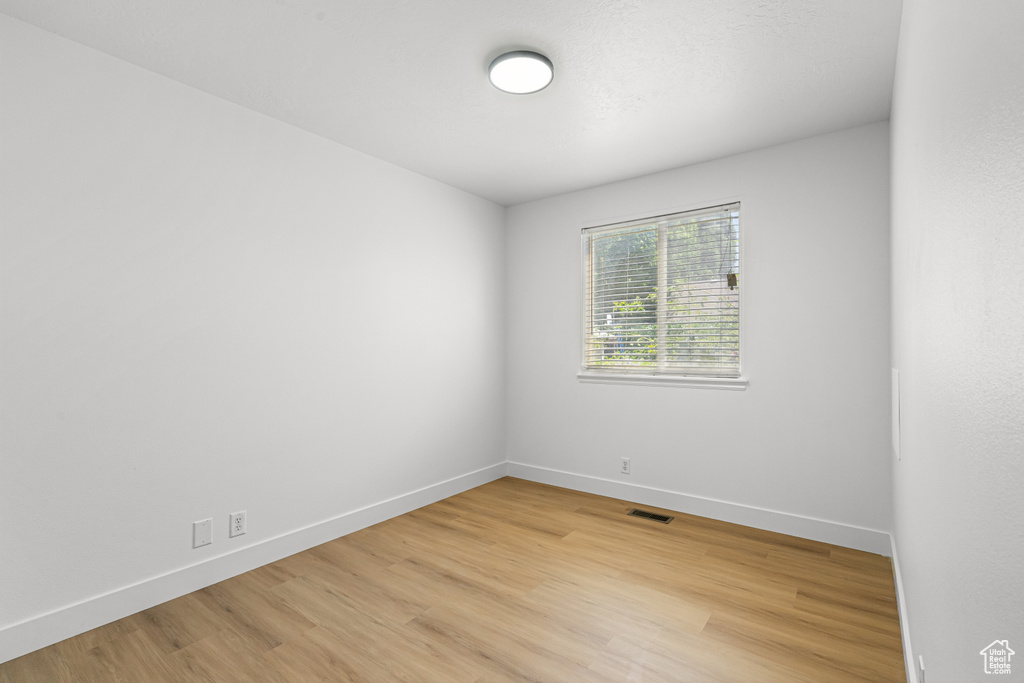 Spare room with light wood-type flooring and baseboards