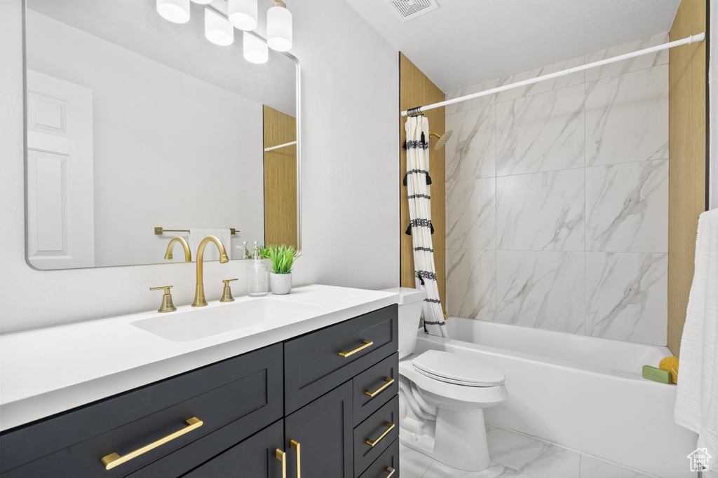 Full bath featuring vanity, marble finish flooring, and shower / bath combination with curtain