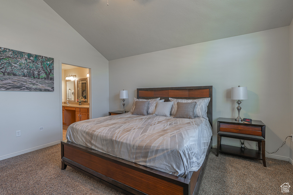 Carpeted bedroom with vaulted ceiling and connected bathroom