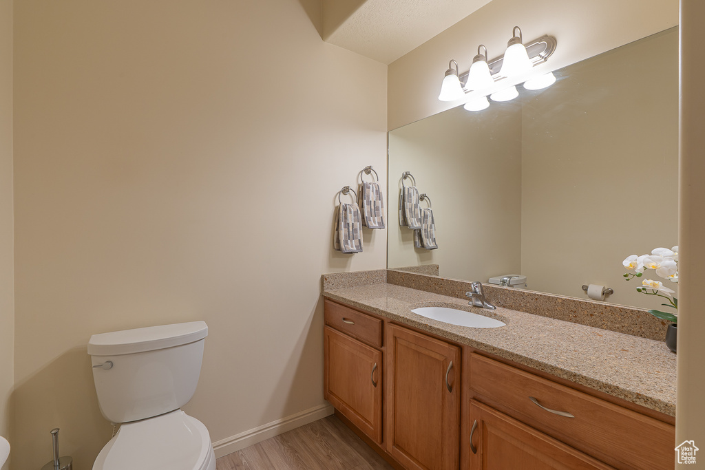 Half bath with vanity and wood finished floors