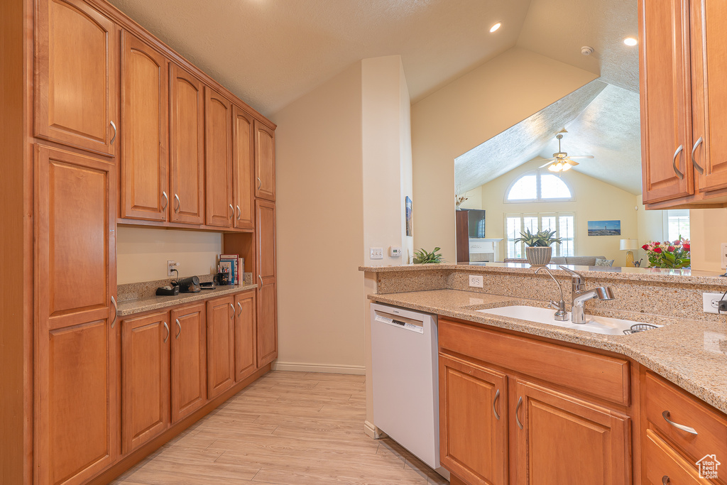 Kitchen with dishwasher, lofted ceiling, light stone countertops, light wood finished floors, and a ceiling fan
