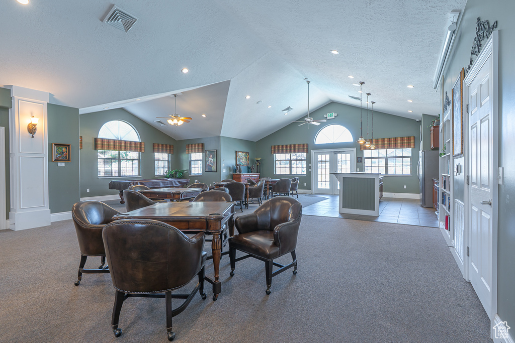 Dining area with a ceiling fan, carpet flooring, vaulted ceiling, recessed lighting, and a textured ceiling