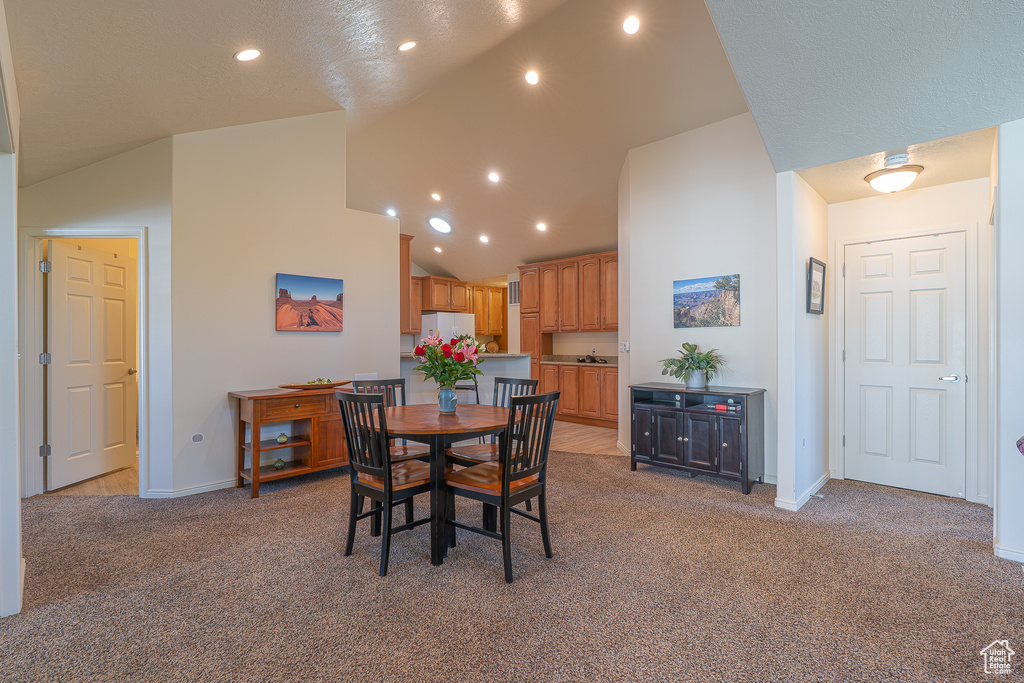 Dining space with light colored carpet, recessed lighting, and high vaulted ceiling