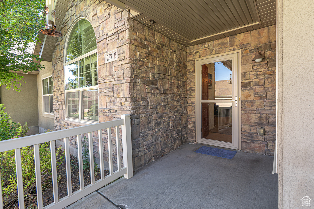 View of exterior entry featuring stone siding and stucco siding
