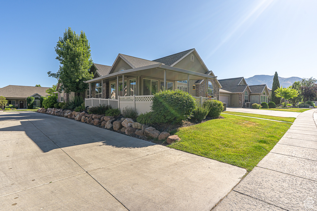 View of home\\\\\\\\\\\\\\\'s exterior featuring concrete driveway, a yard, a residential view, a mountain view, and roof with shingles
