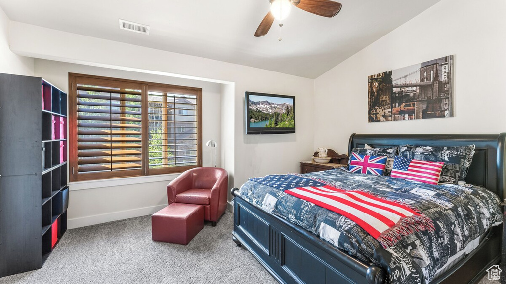 Carpeted bedroom with lofted ceiling and ceiling fan