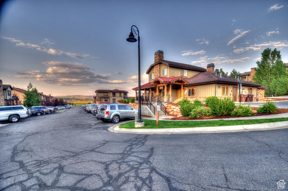 View of front of home featuring a chimney and uncovered parking