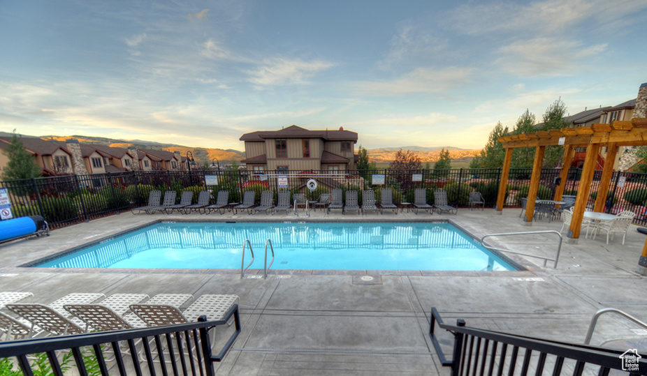 Community pool with a pergola, a patio, and a mountain view