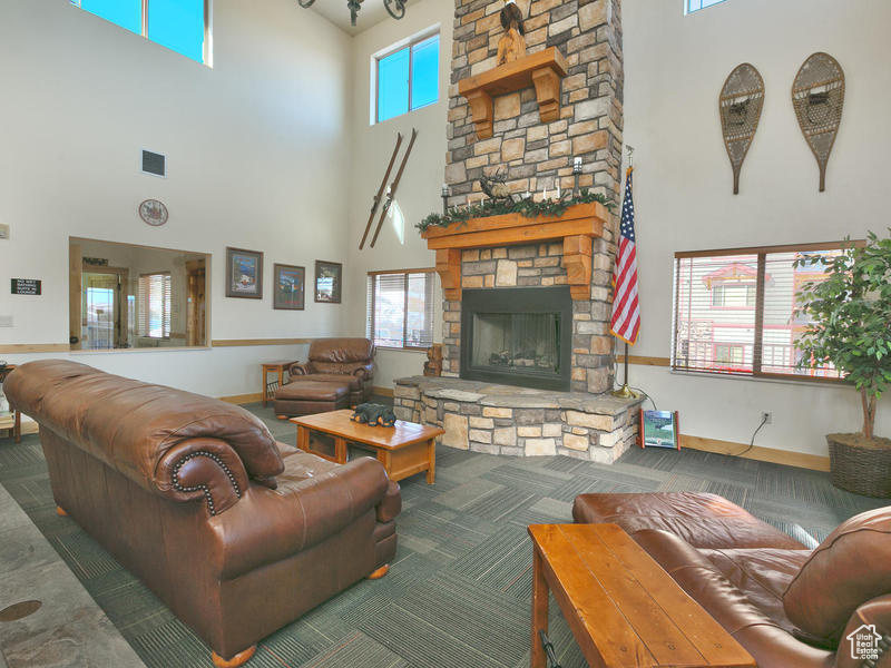Living room featuring a high ceiling and a stone fireplace