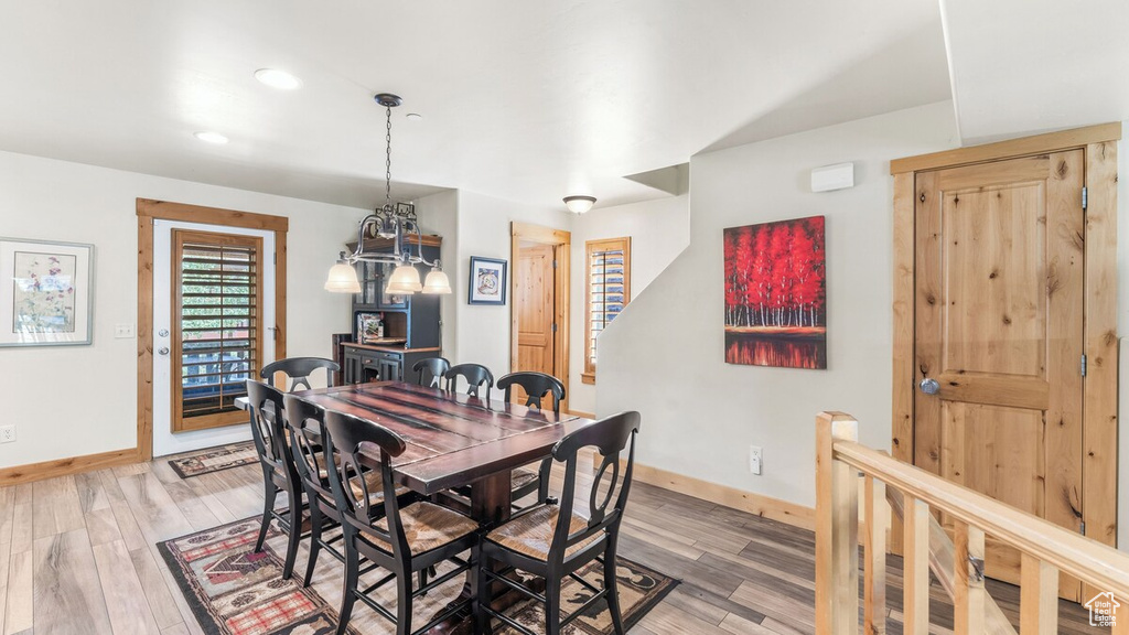 Dining room with light wood-type flooring, a chandelier, and recessed lighting