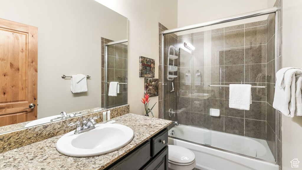 Bathroom with vanity and enclosed tub / shower combo