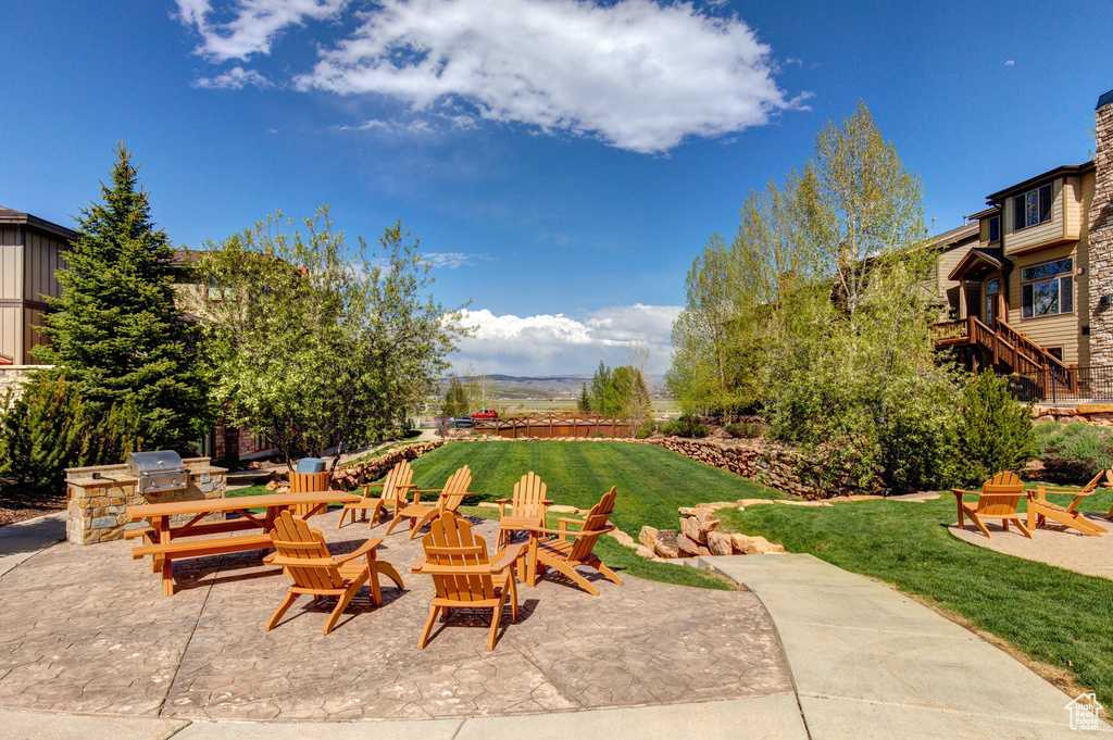 View of patio with a fire pit and exterior kitchen