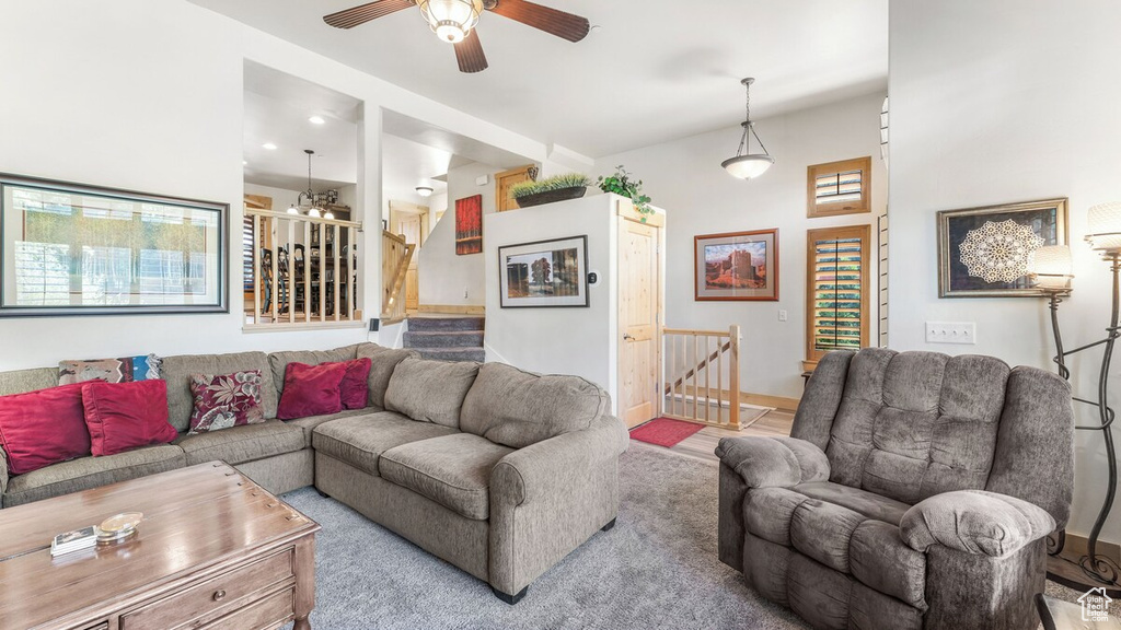 Living room featuring ceiling fan and stairs