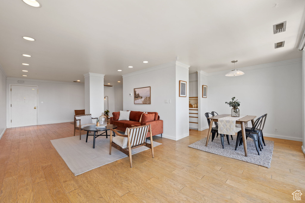 Living room featuring light wood finished floors, recessed lighting, and crown molding