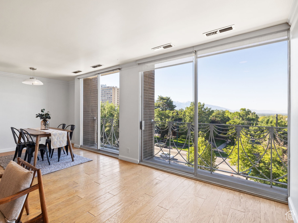 Dining room with light wood-type flooring and floor to ceiling windows