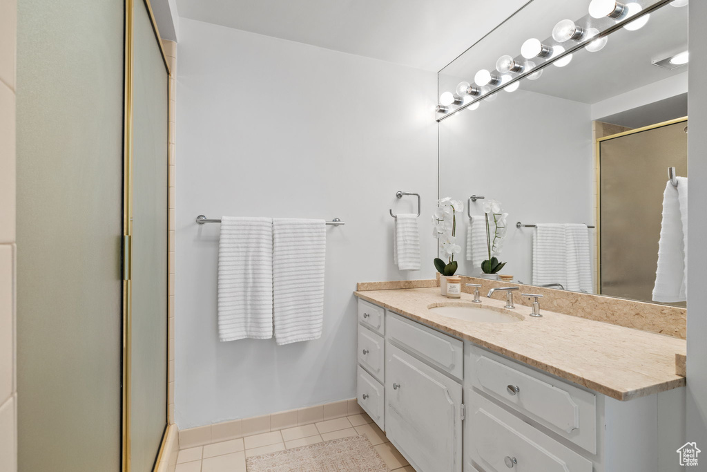 Bathroom featuring vanity, a shower stall, and tile patterned flooring
