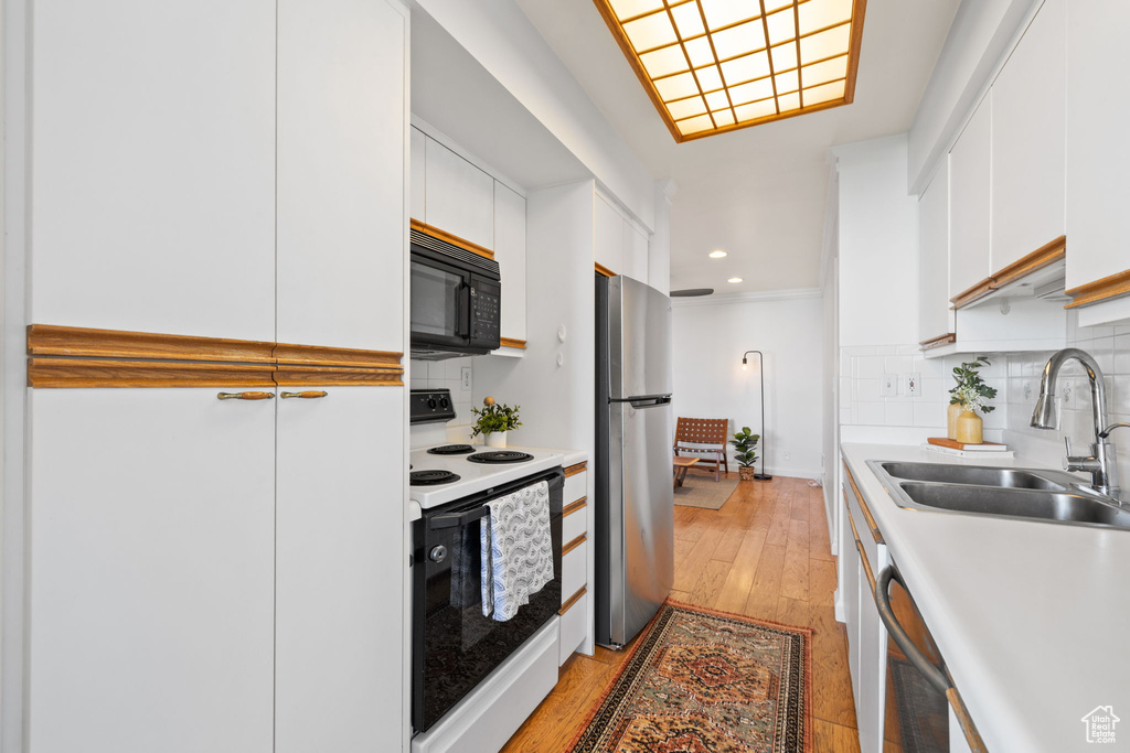 Kitchen with stainless steel appliances, white cabinetry, tasteful backsplash, light countertops, and recessed lighting