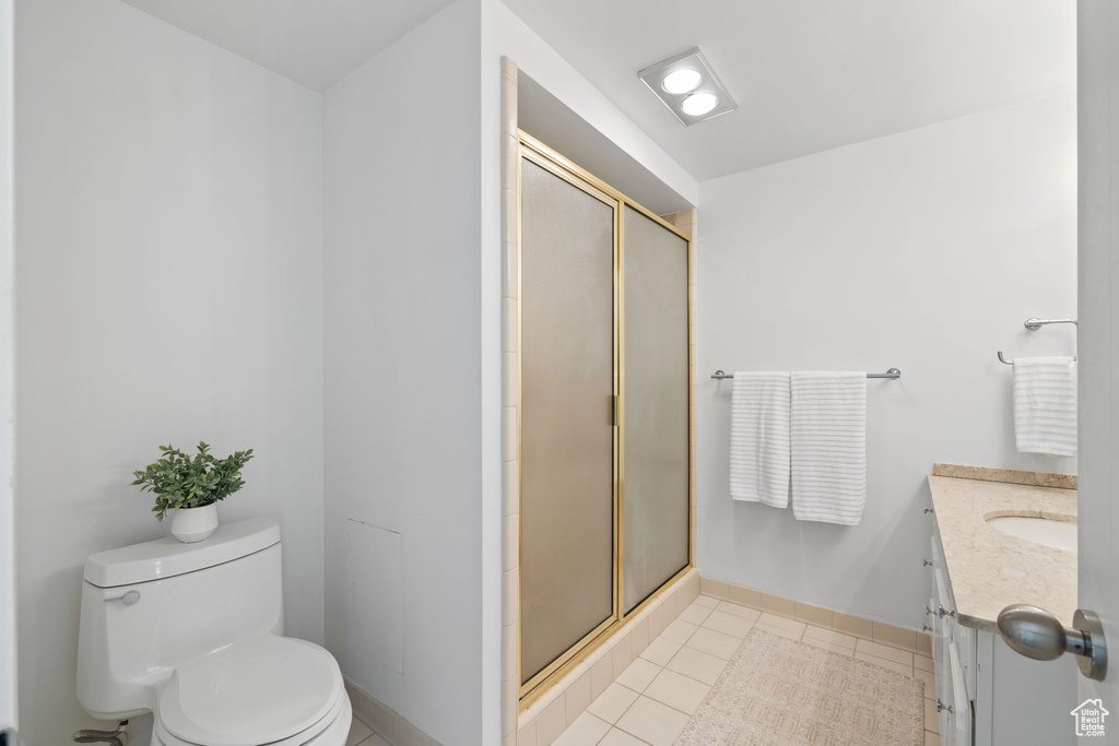 Bathroom with vanity, a stall shower, and tile patterned flooring