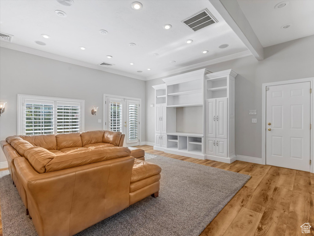Living room with ornamental molding, light wood finished floors, and recessed lighting