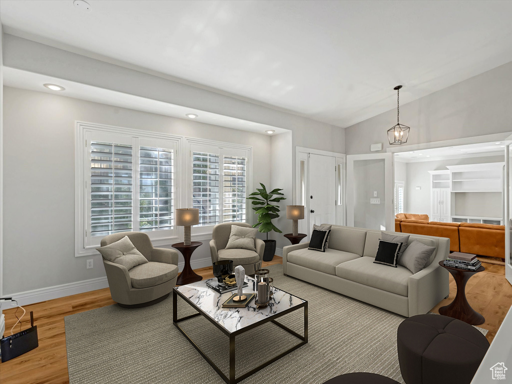 Living area featuring wood finished floors, vaulted ceiling, and recessed lighting