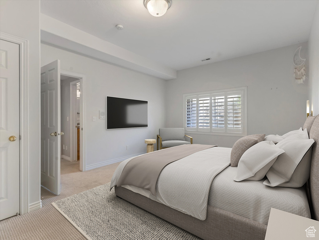 Bedroom featuring light colored carpet and baseboards