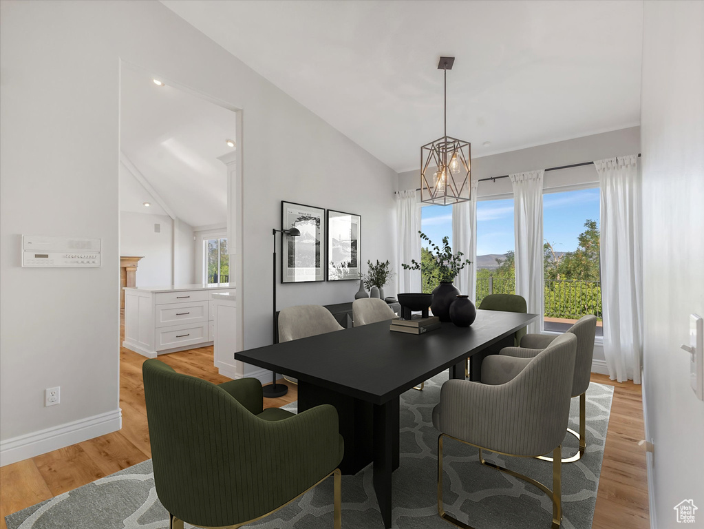 Dining space with a chandelier, light wood finished floors, and lofted ceiling