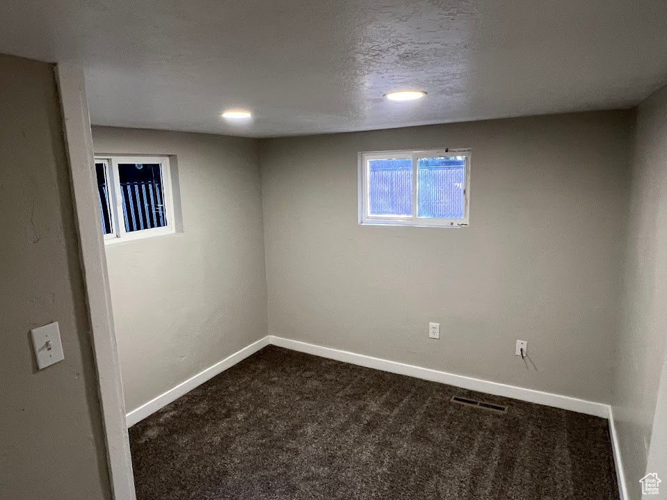 Below grade area with dark colored carpet and recessed lighting