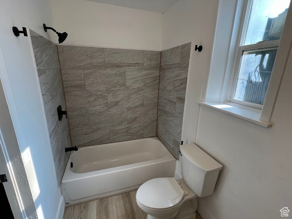 Bathroom featuring bathtub / shower combination and wood finished floors