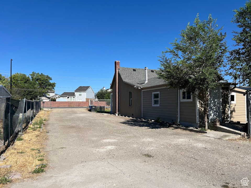 View of home's exterior with a chimney and driveway