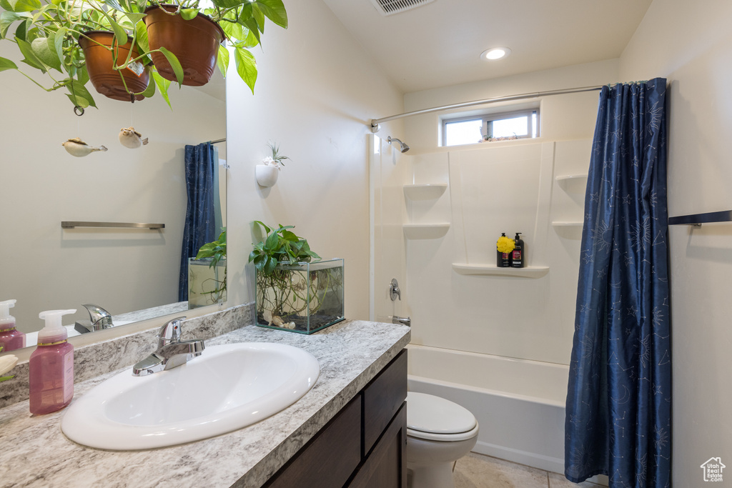 Bathroom with vanity, shower / tub combo, and tile patterned flooring