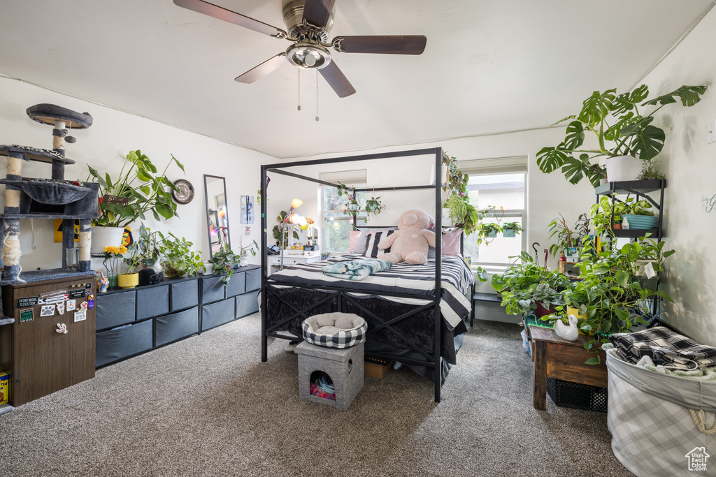 Carpeted bedroom featuring ceiling fan
